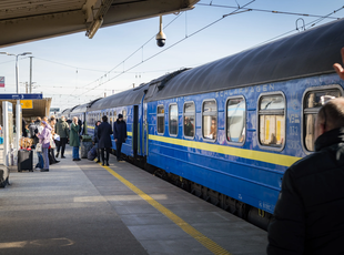 Kyiv-Express train from Kyiv arriving at Warsaw East staion, a person walking into the frame from the right is greeting disembarking passengers