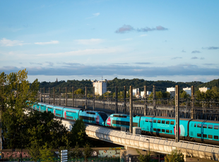 Two TGV trains coupled together running on a bridge during golden hour