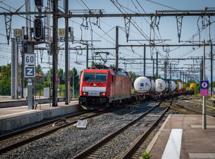 Alstom Traxx locomotive of DB passing with frieght through a train station